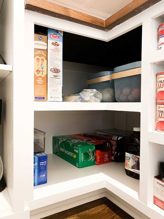 How I Organize My Walk-In Farmhouse Pantry base corner cabinet for bulk produce and drinks.